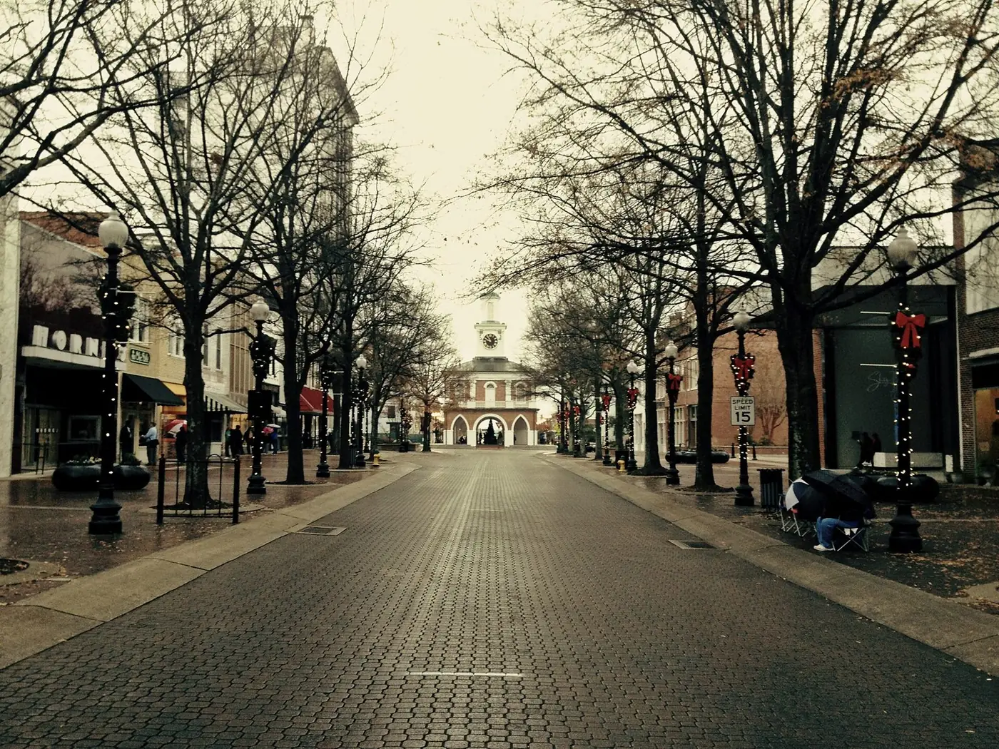 Brick-paved Hay Street lined with bare trees and lamp posts, leading to the Market House